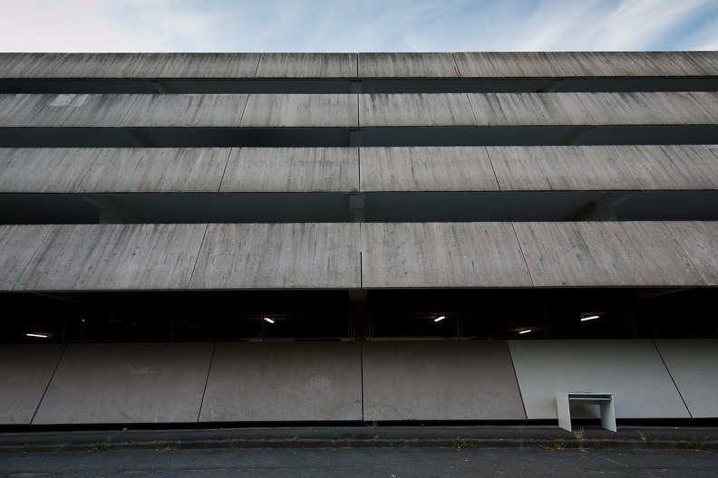 Bureau abandonné devant la façade en béton du parc de stationnement régional