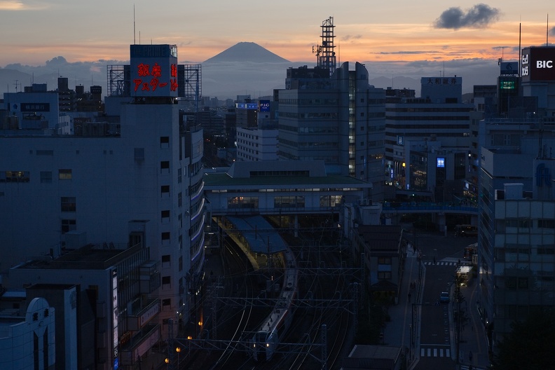 Un train N'EX quitte la gare devant le mont Fuji dans le bleu du crépuscule