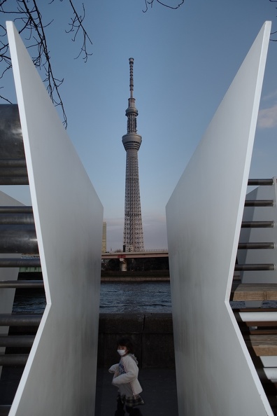 Fillette portant un masque sanitaire passant devant la Tokyo Skytree